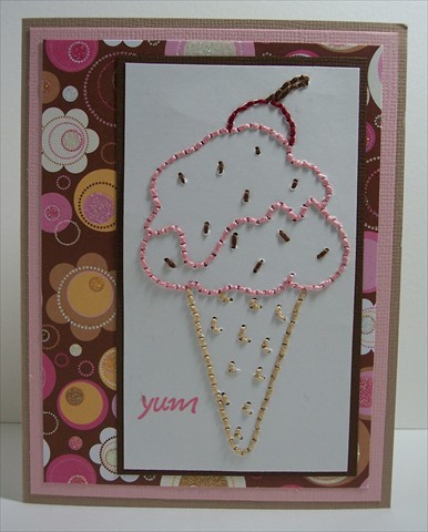 Supplies:  Yum rubber stamp (Pink Cat Studio), ice cream cone iron on transfer, DMC Pearl Cotton, Bazzill Cardstock, DCWV Glitter Stack, piercing tool and mat, embroidery needle